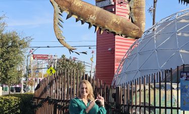 Large crab sculpture at Fremont Street in Las Vegas with a woman posing nearby.