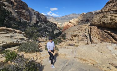 Hiker exploring the stunning red rock formations in Red Rock Canyon, Las Vegas.
