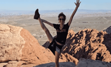 Woman doing a yoga pose on rocks at Red Rock Canyon, Nevada.