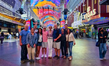 Group of tourists enjoying a vibrant night photo tour on the Las Vegas Strip.