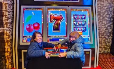 Two women enjoying a slot machine game at Fremont Street, Las Vegas.