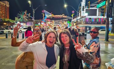 Fremont Street experience in Las Vegas with happy tourists enjoying the vibrant nightlife.