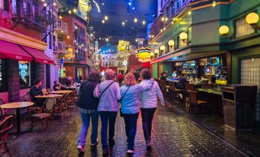 Group of friends walking through vibrant Las Vegas downtown at night.