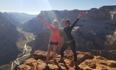 Two women celebrating on a Zion Canyon overlook during a full-day eBike and hiking tour.