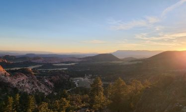 Scenic Zion National Park landscape during sunset with mountains and trees.