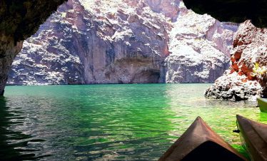 Scenic view of Black Canyon with kayaks in the foreground and rugged cliffs in the background.