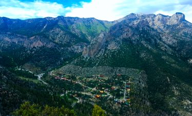 Scenic view of Mt Charleston with lush green mountains and a small town below.