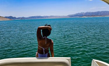Woman enjoying a boat cruise on Lake Mead with scenic mountain views.